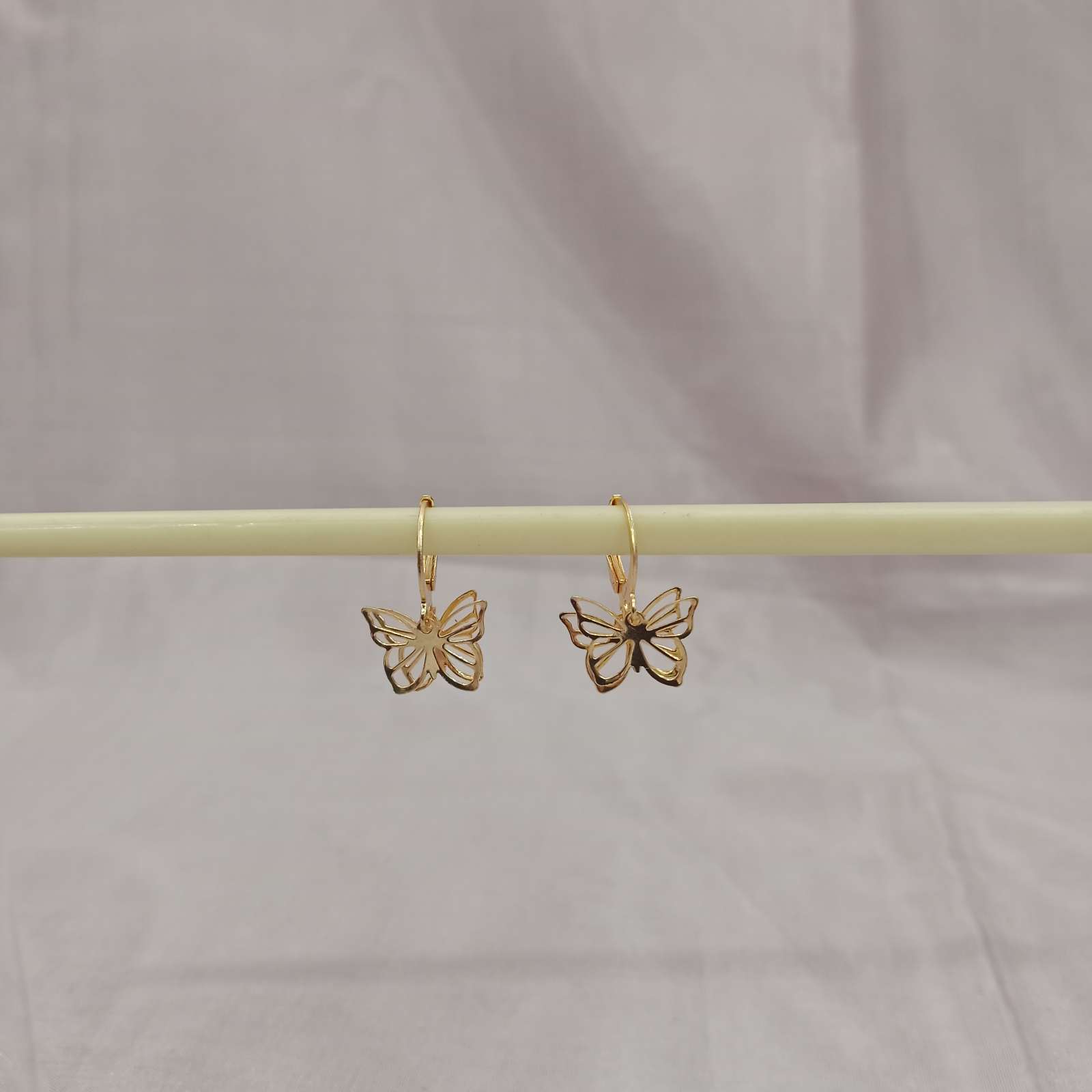 Golden Butterfly Cutout Earrings – side view on bar